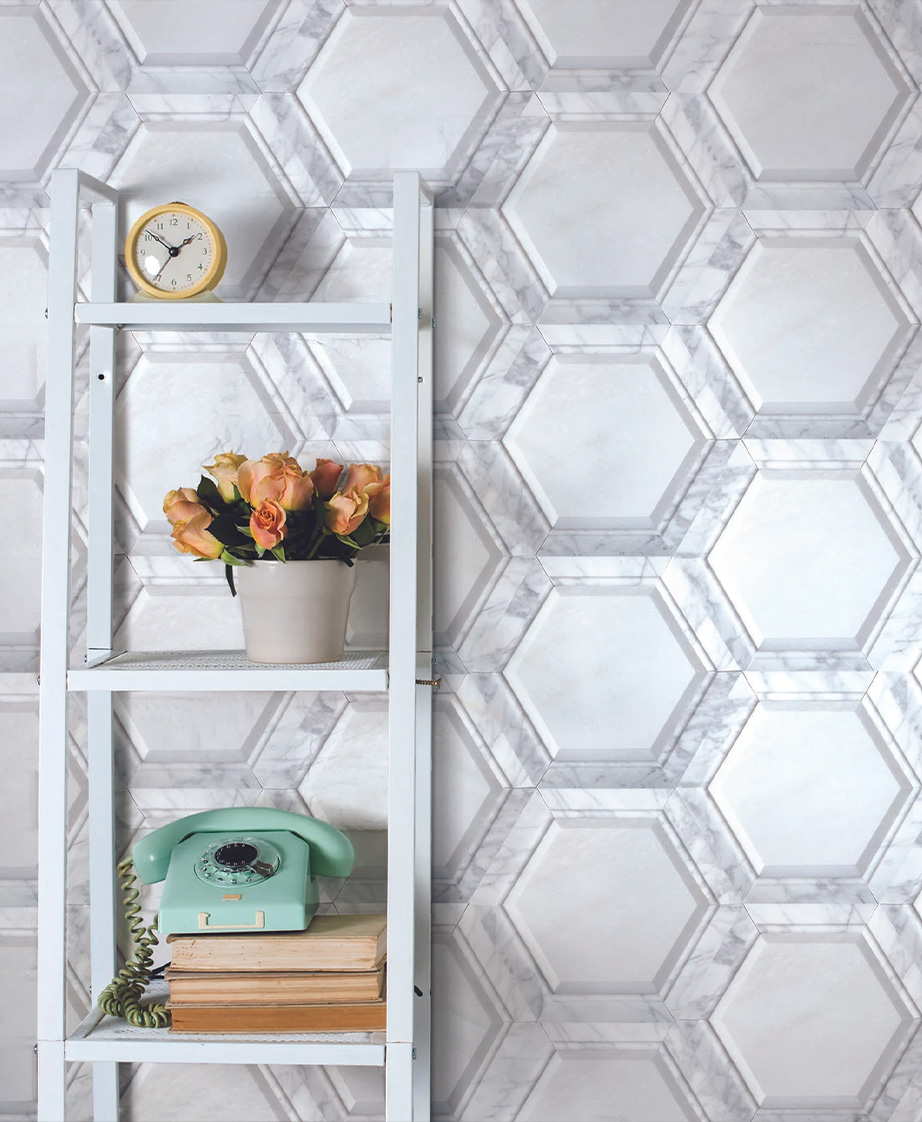 White bookstand with a phone, books, flowers and clock against a white Puccini tile wall.