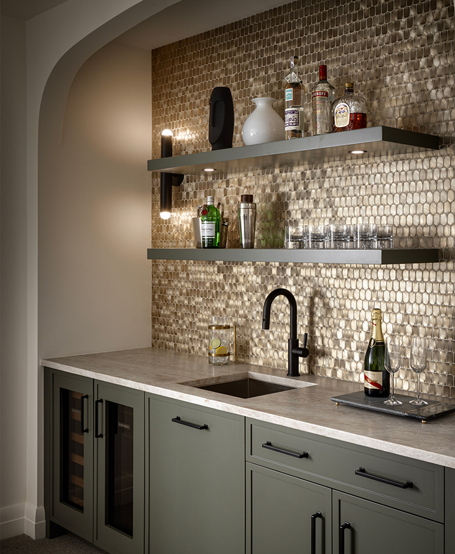 Home bar with metallic tile backsplash, open shelving, and black hardware.