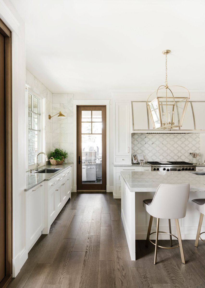 Kitchen with white cabinets, countertops and large range in the background.
