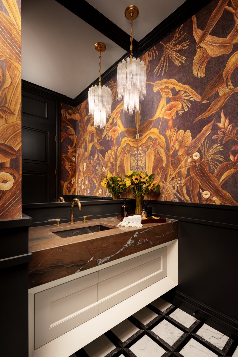 Bathroom vanity with rock cut countertop and brown floral wallpaper.